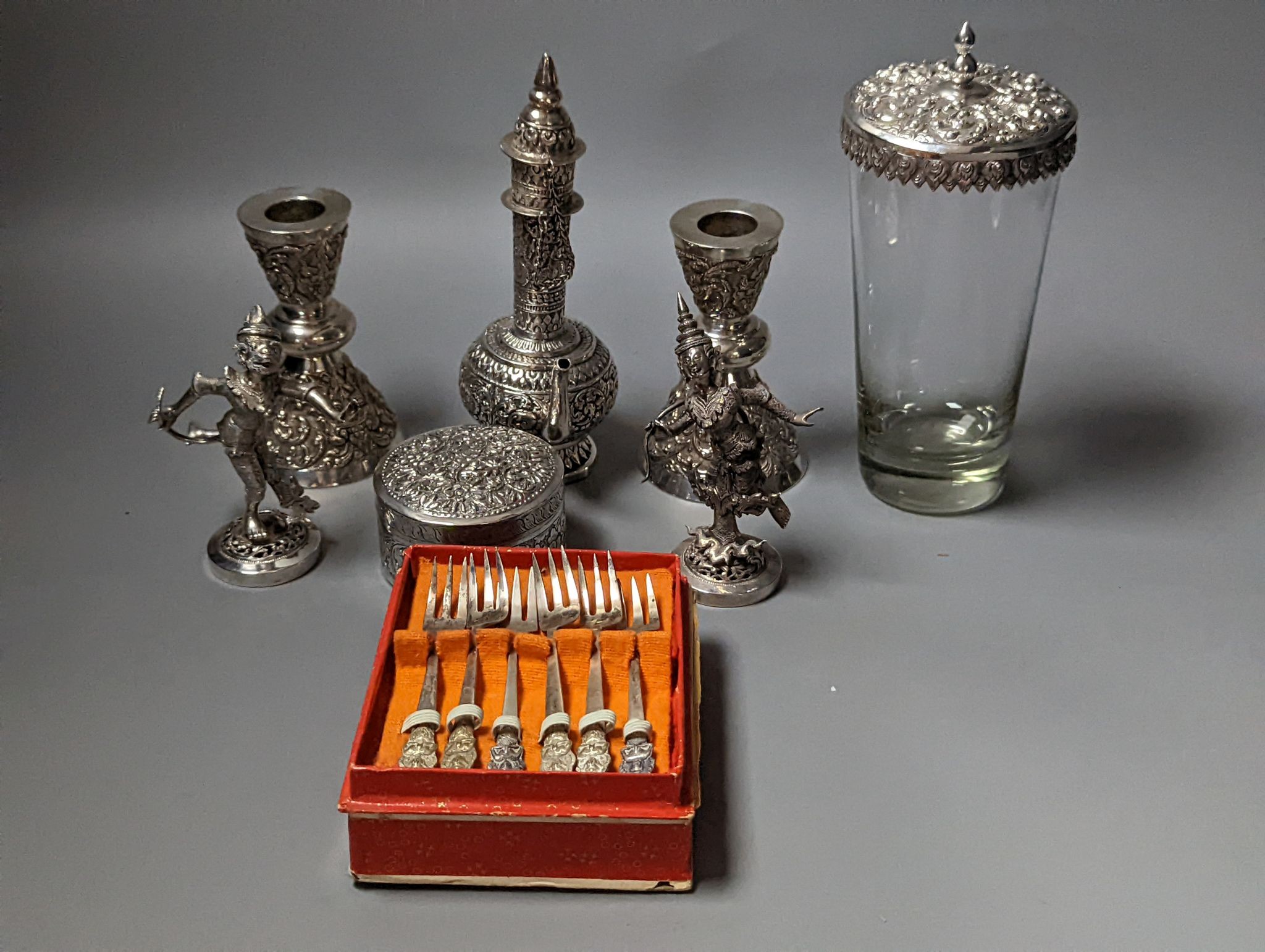 A collection of assorted white metal items including Thai boxes, Burmese figures of dancers, dishes, candlesticks, tea strainer etc. and a quantity of assorted boxed flatware.